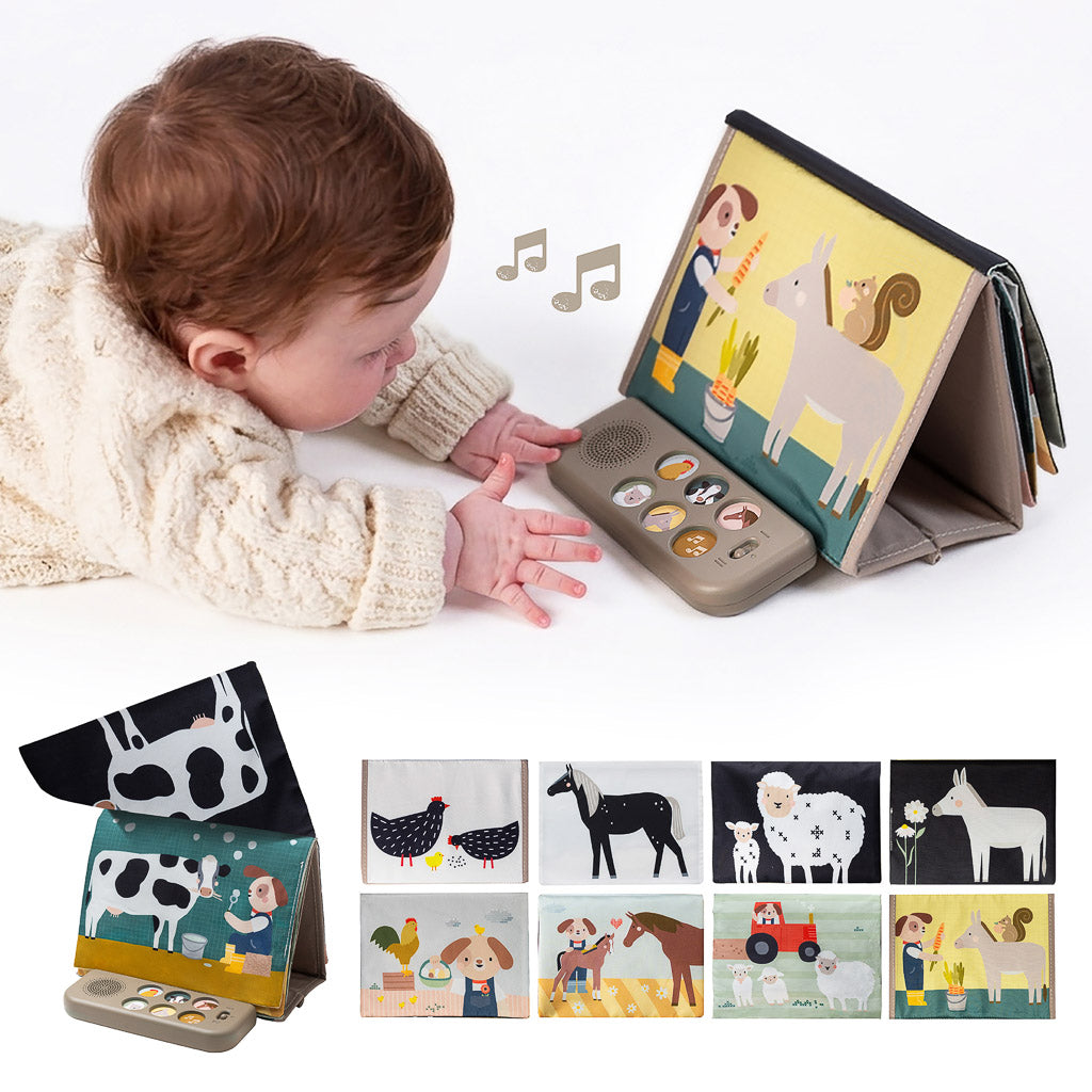Baby lying on tummy pressing the sound pad of the Taf Toys Farm Musical Tummy Time Book