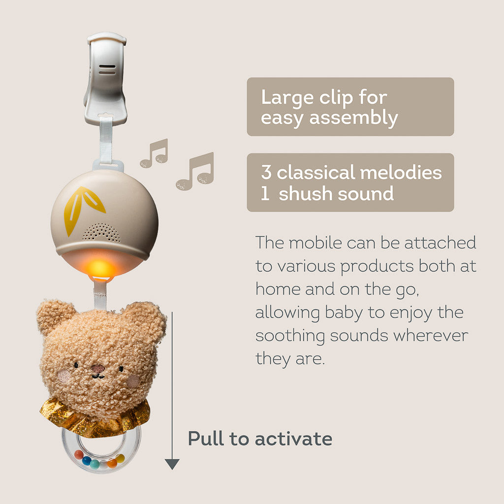Diagram showing the Taf Toys soothing bear with large attachment clip, 3 classical melodies, shush sound, and pull-to-activate mechanism