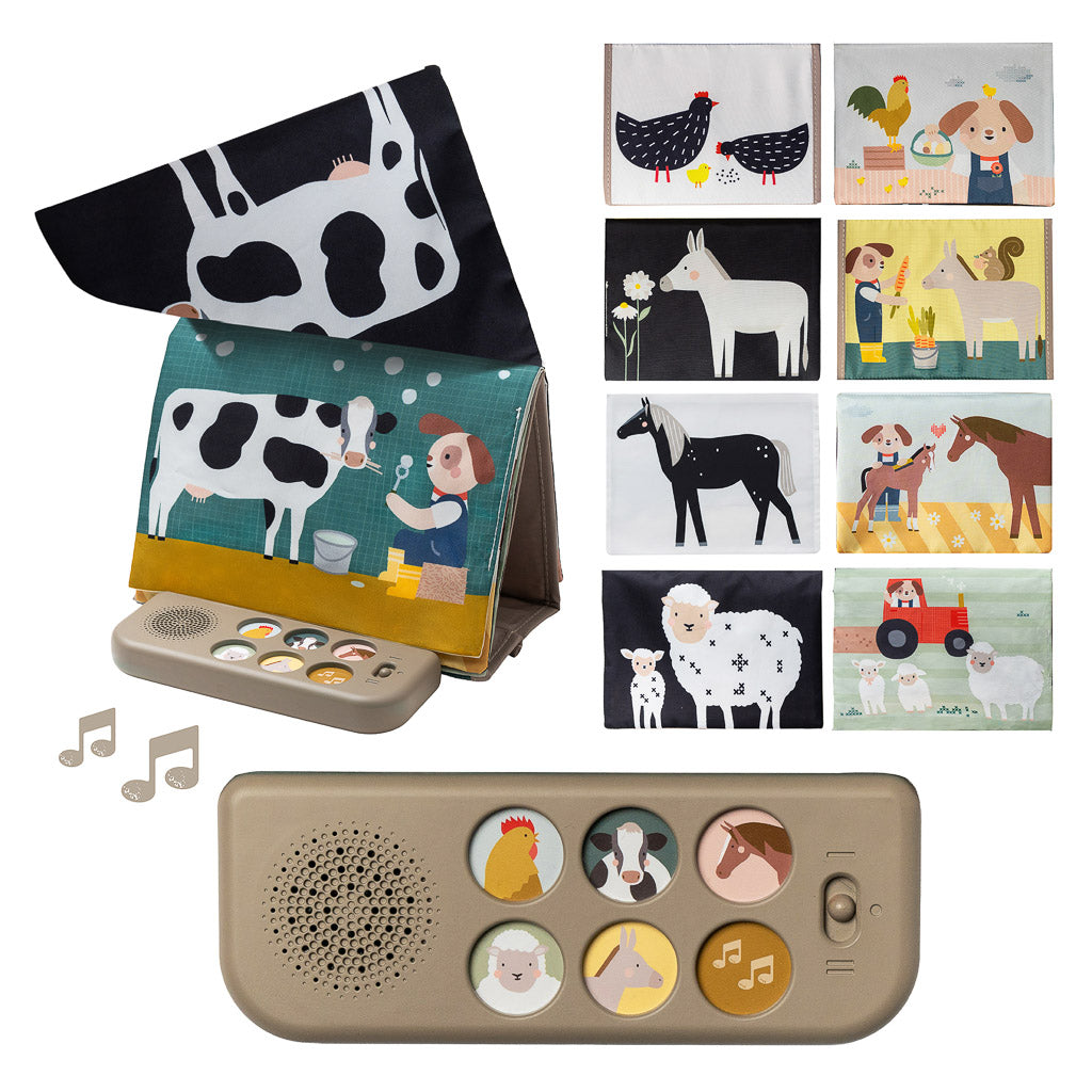 Baby lying on tummy pressing the sound pad of the Taf Toys Farm Musical Tummy Time Book
