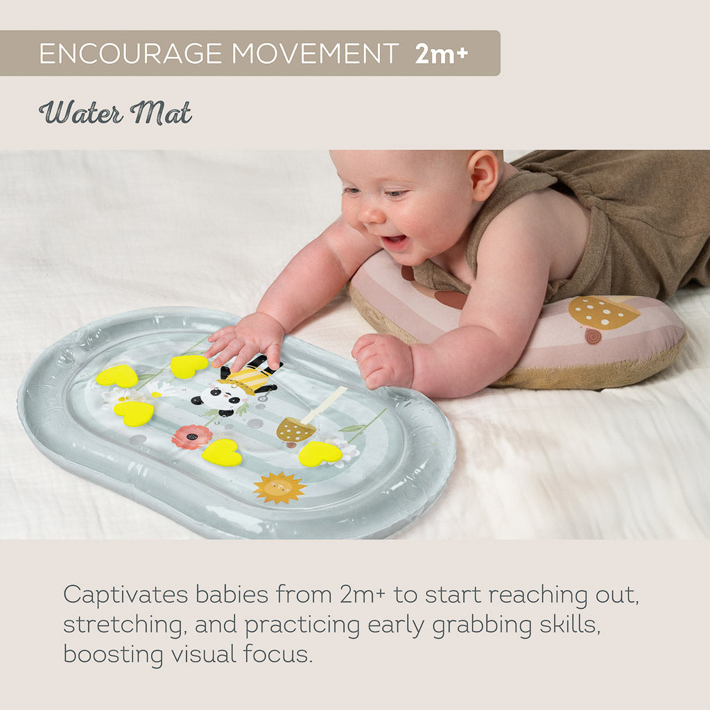 Infant resting on tummy pillow pushing on Taf Toys sensory water mat for 2M+ movement and reach practice
