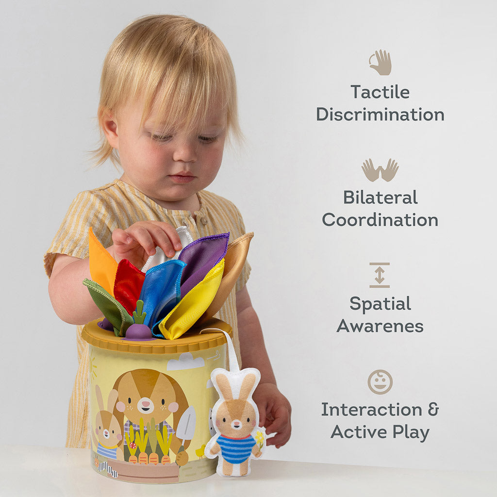 Toddler playing with Taf Toys Pop & Pull Tissue Box demonstrating tactile discrimination and bilateral coordination